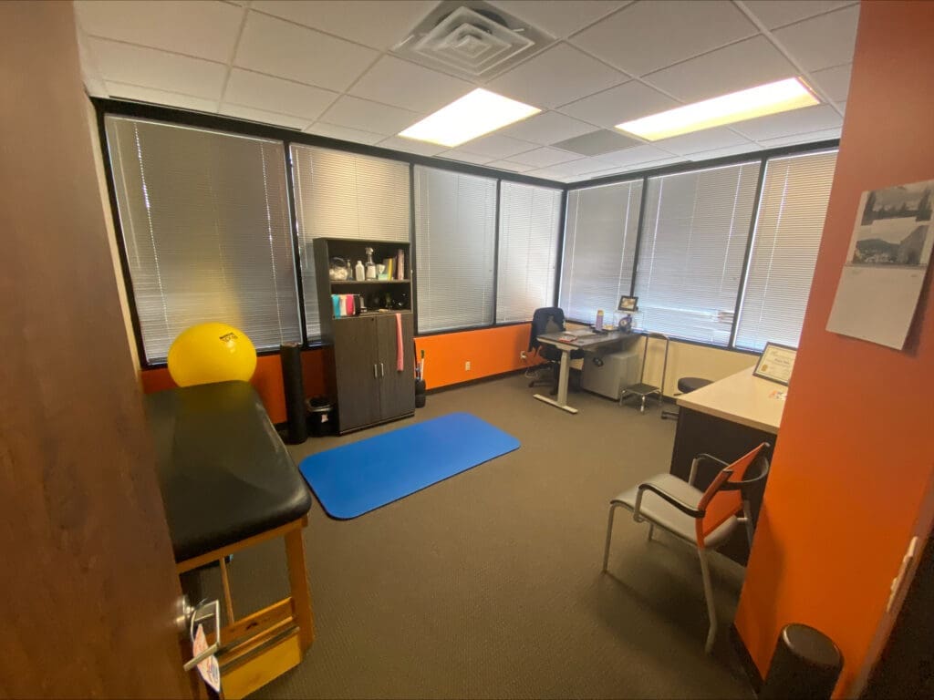 An interior view of the recovery room at Airrosti West U. Exercise ball, mat, and table are featured