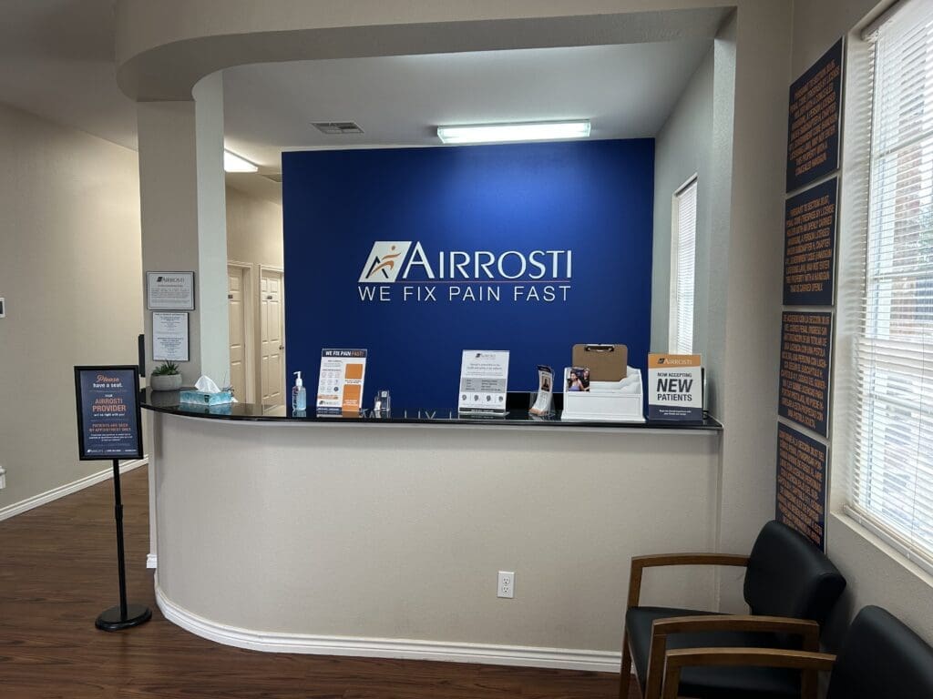 Interior lobby view at Airrosti West Fort Worth. Airrosti branding on wall.