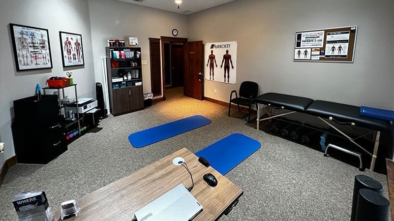 A photo showing the inside recovery room at Airrosti Main Place. Exercise mats and foam rollers are visible in the room