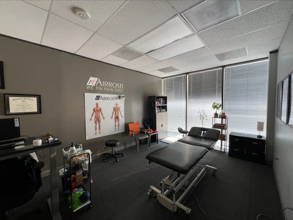 A photo of the treatment room at Airrosti Tanglewood. The treatment tableis featured in the center of the room