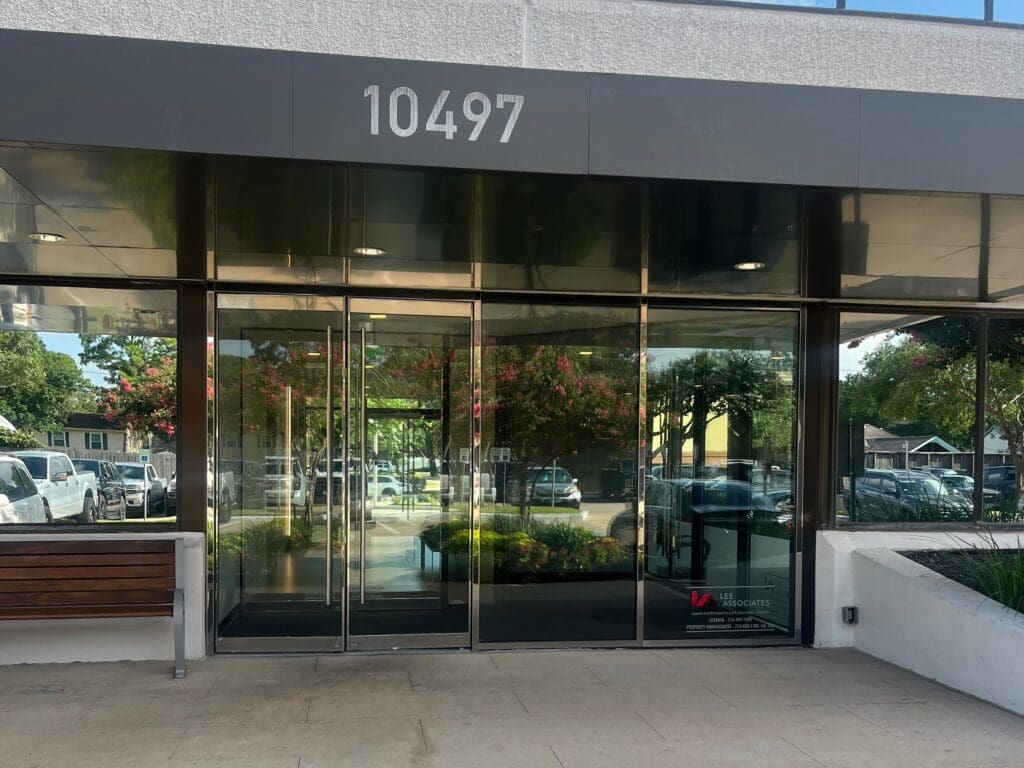A close up photo of the exterior entrance of the main building where Airrosti Memorial City is located.