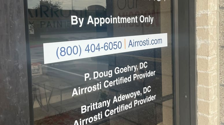 A close up photo of the nameplate on the exterior front door at Airrosti Katy