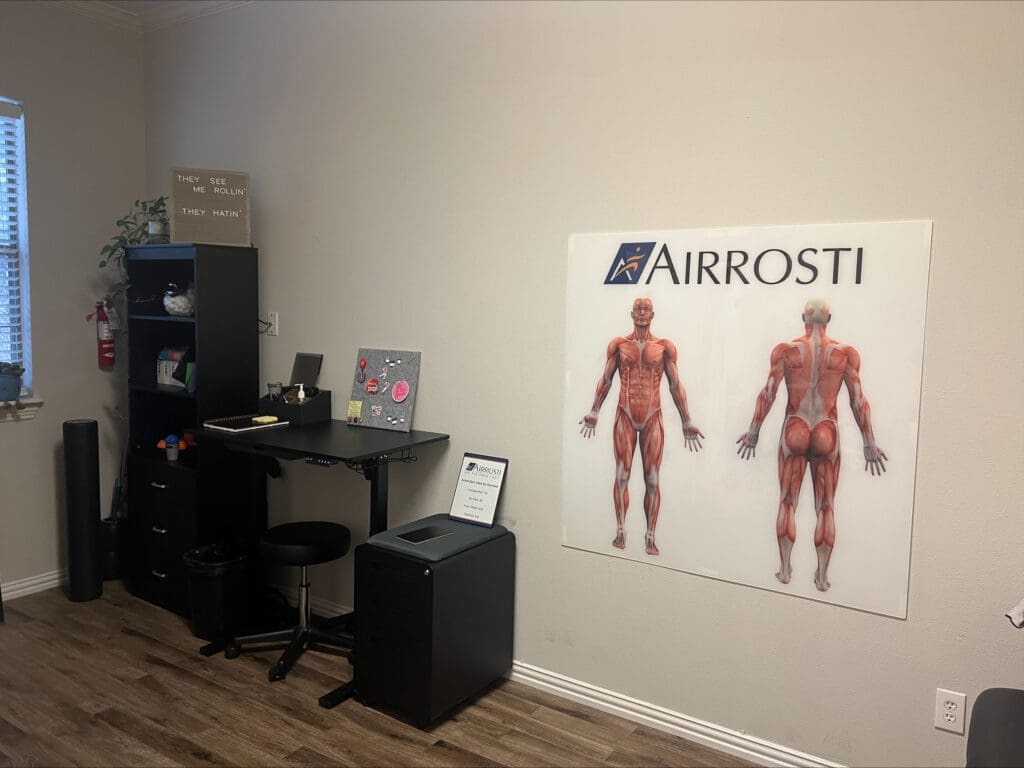 An interior photo of the recovery room at Airrosti Weatherford. The photo includes a poster of the musculoskeletal man