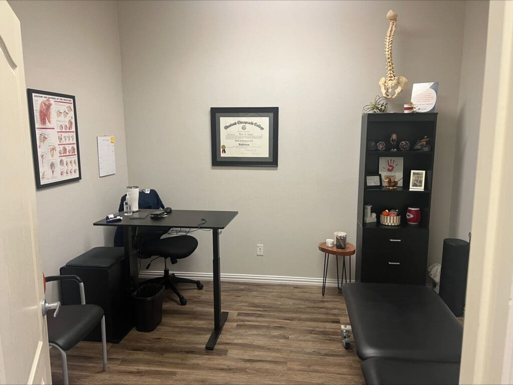 An interior photo of the treatment room at Airrosti Weatherford. The phone includes the treatment table and the provider's desk. The Providers degree is hanging on the wall.