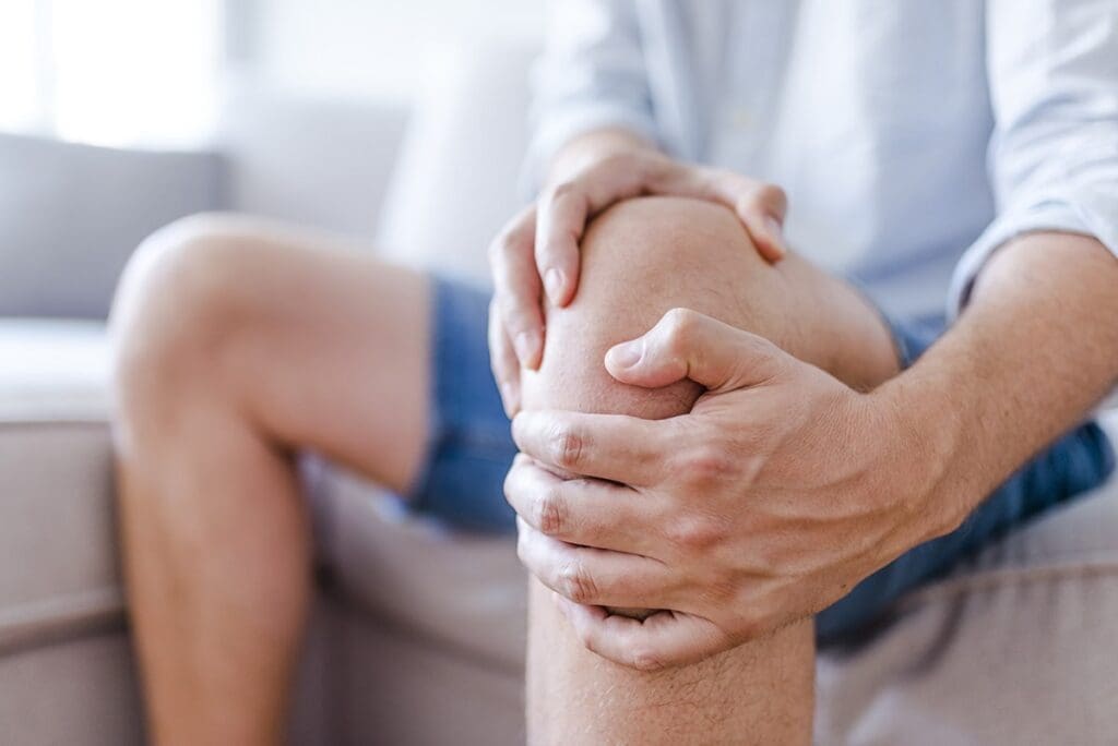 man holding knee in pain